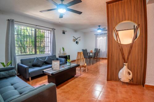 a living room with a blue couch and a mirror at Peach35 Apartamento centrico, 5 min de la playa in Cancún