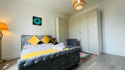 1 dormitorio con sofá y 1 cama con almohadas amarillas en Entire Pet Friendly Apartment Self Check In, en Fife