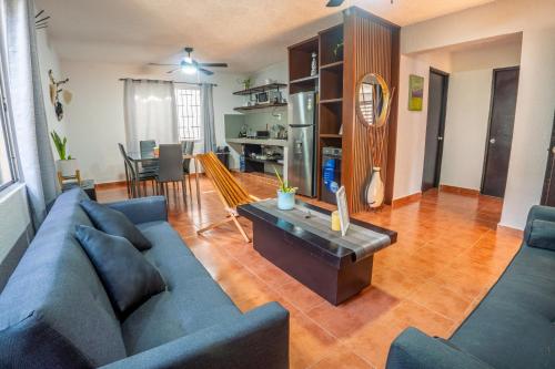 a living room with a blue couch and a table at Peach35 Apartamento centrico, 5 min de la playa in Cancún