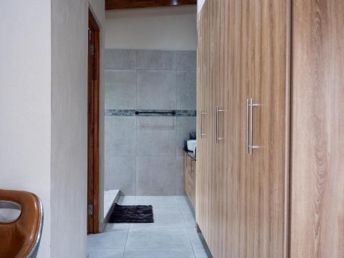 a bathroom with a wooden cabinet and a tub at Kruger Maroela Lodge in Marloth Park