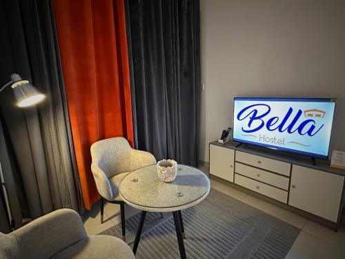 a living room with a table and a television at Bella INN - Deluxe Master rooms with Balcony - No Smoking in Dubai