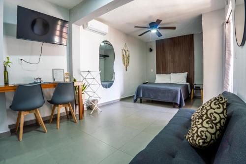 a living room with a couch and a bed at Peach35L Céntrico studio super ubicado y tranquilo in Cancún