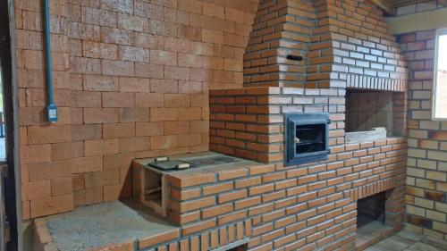 una pared de ladrillo con un horno de ladrillo en ella en Suíte família SOL & LUA Guarda do Embaú SC, en Guarda do Embaú