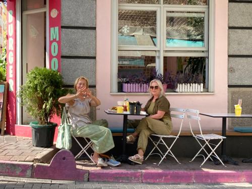 Due donne sedute a un tavolo fuori da un edificio di Balat Butik Hotel a Istanbul