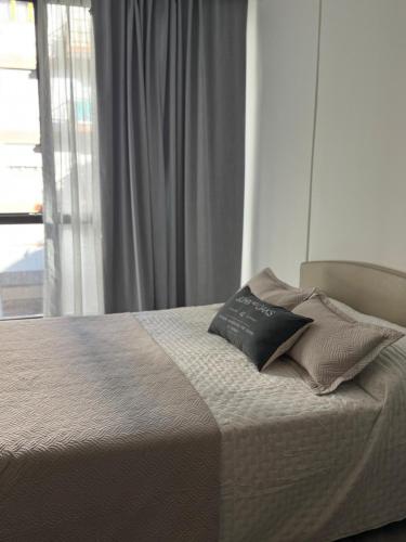 een bed met twee kussens erop in een slaapkamer bij Brooklyn Suites MDP in Mar del Plata