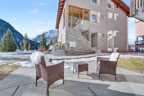 eine Terrasse mit Stühlen und einem Tisch vor einem Haus in der Unterkunft Comfort and space for families, 3 bedrooms and garden in Arni Alp