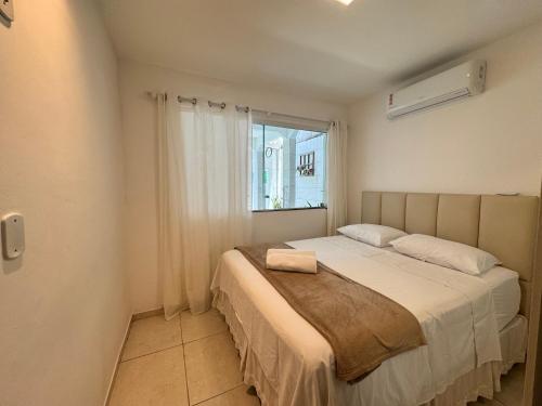 una camera da letto con un letto grande con una finestra di Casa Tranquila a Vitória