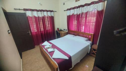 a small bedroom with red curtains and a bed at Blue Hills View in Attappādi