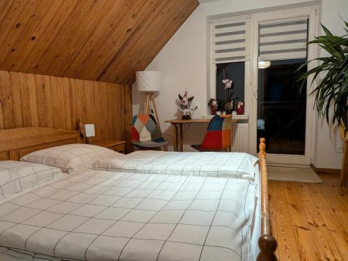 Un dormitorio con dos camas y una ventana. en Apartament Forest, en Mysłakowice