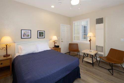 a bedroom with a blue bed and two chairs at Coastal Glow in Oceano
