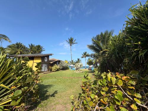 un cortile con palme e una casa di Vila BeiradeiRô - Taipu de Fora a Taipu