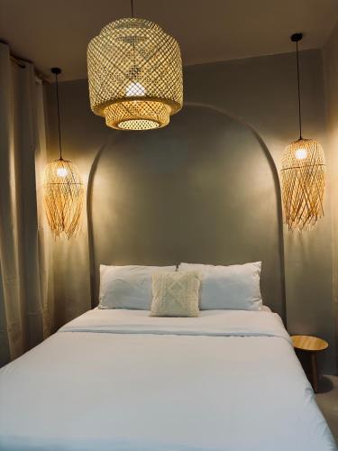 a bedroom with a white bed with two lights at Arko Villa in Katangawan