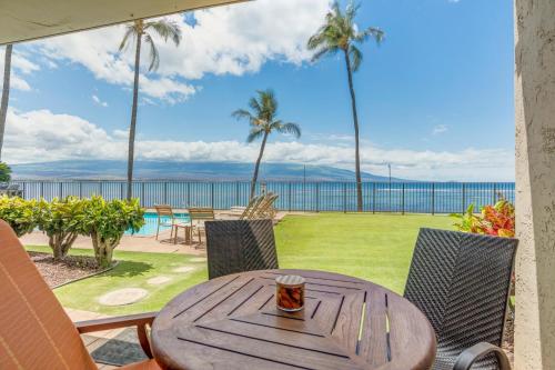 a wooden table with a cup of coffee on a patio at Lauloa 102 in Wailuku