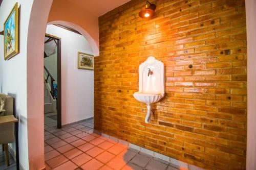 a bathroom with a urinal on a brick wall at Casa de veraneio de frente à praia de Tabatinga - RN in Nísia Floresta