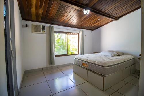a bedroom with a bed and a window at Casa de veraneio de frente à praia de Tabatinga - RN in Nísia Floresta