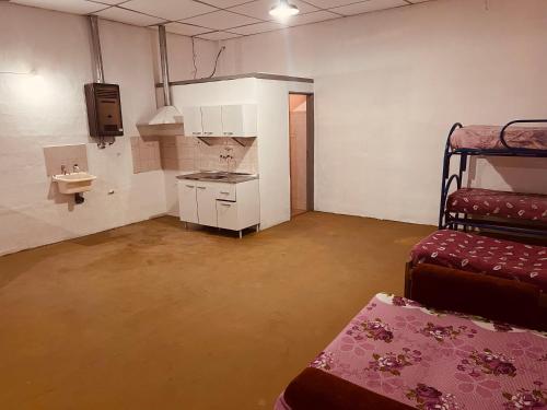 een lege kamer met een stapelbed en een keuken bij Doma y folklore in Colonia Caroya