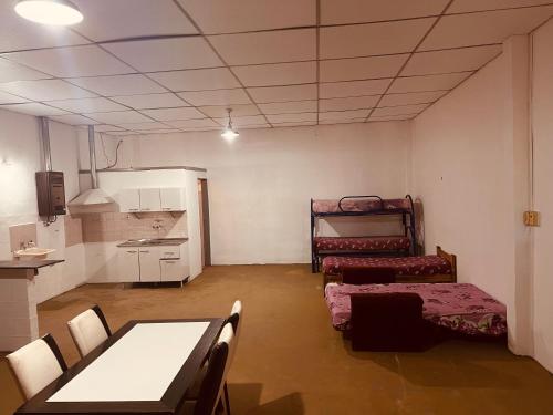 een kamer met een tafel en stoelen en een keuken bij Doma y folklore in Colonia Caroya