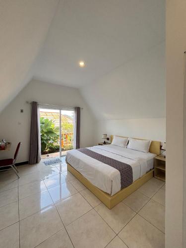 a bedroom with a large bed and a window at Tumpaksewu Bungalows in Sidomukti