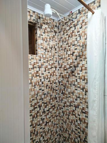 a bathroom with a shower with a tiled wall at Casa Laurus in São Sebastião