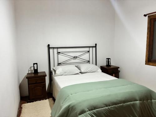 ein Schlafzimmer mit einem großen Bett mit zwei Nachttischen in der Unterkunft Rincón del roble in Veinticinco de Mayo