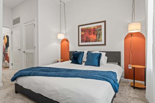 a bedroom with a large bed with blue pillows at Riviere Apartments King Bed Suite & Pool & Gym & Pet Friendly & Near Epic Universe in Orlando