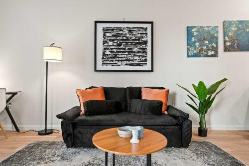 a living room with a black couch and a table at Riviere Apartments King Bed Suite & Pool & Gym & Pet Friendly & Near Epic Universe in Orlando