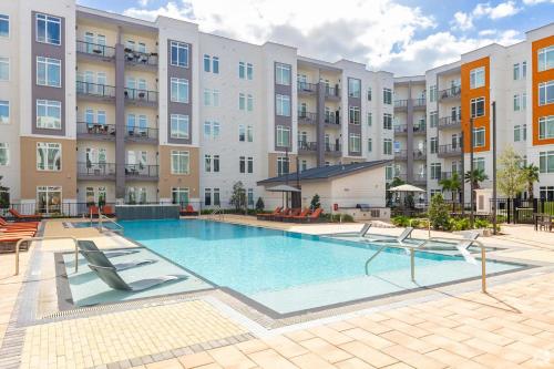 an image of a swimming pool at a apartment complex at Riviere Apartments King Bed Suite & Pool & Gym & Pet Friendly & Near Epic Universe in Orlando