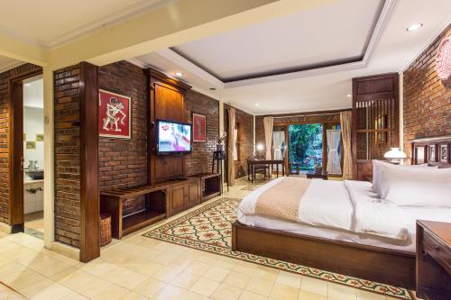a bedroom with a bed and a flat screen tv at Duta Boutique Villa in Yogyakarta