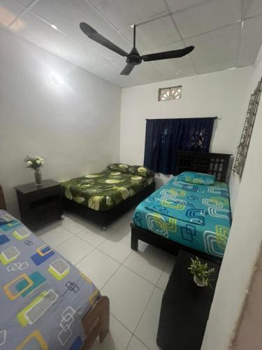 a bedroom with two beds and a ceiling fan at Squid Hostel in Santa Marta