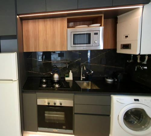een keuken met een magnetron, een spoelbak en een wasmachine bij Viamonte Che! in Buenos Aires