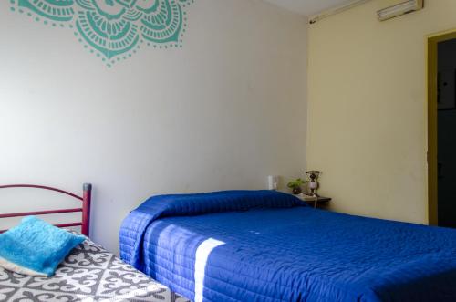 a bedroom with a bed with blue sheets on it at Hospedaje Jazmin Cosquín in Cosquín