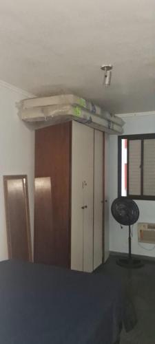 a room with a room with a bed and a closet at apartamento 1 quarto in Guarujá