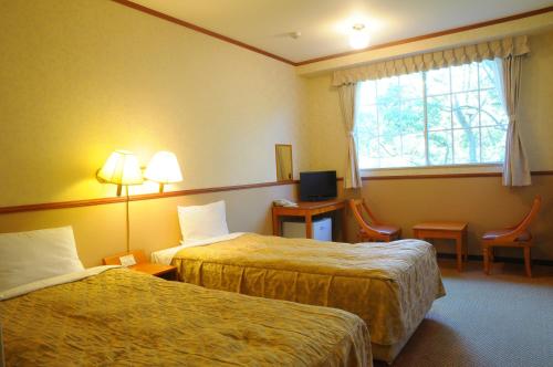 熱海的住宿－熱海派普諾凱穆里酒店，酒店客房设有两张床和窗户。