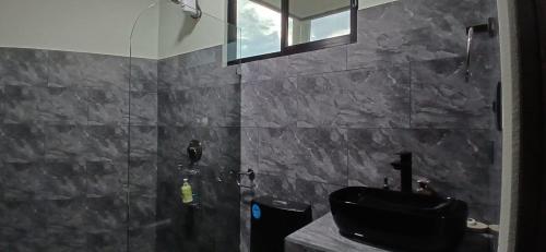 a bathroom with a black sink and a shower at Apartamentos Jireh in Quepos