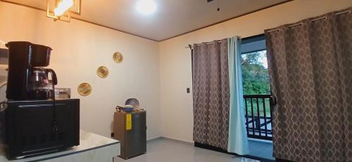 un soggiorno con TV e finestra di Apartamentos Jireh a Quepos