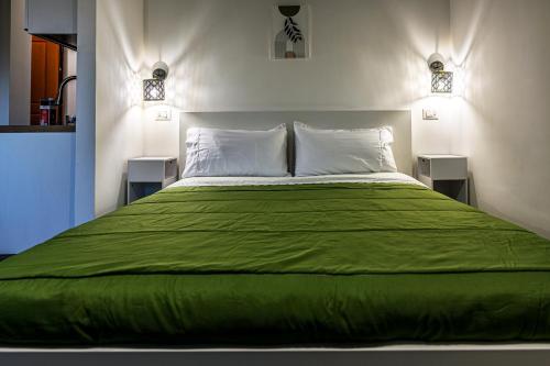 ein Schlafzimmer mit einem großen Bett mit grüner Bettwäsche und Kissen in der Unterkunft Supernova House in Aranova