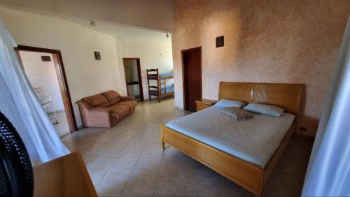 ein Schlafzimmer mit einem Bett und einer Couch in einem Zimmer in der Unterkunft Casa da praia pousada in Peruíbe