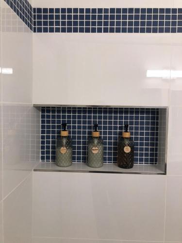 three bottles sitting on a shelf in a bathroom at Mt Pleasant Retreat - Entire Brand New Apt in NW DC - Walk to Metro, Zoo, Adams Morgan - Parking, Dog Friendly in Washington, D.C.