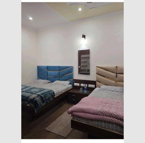 ein Schlafzimmer mit zwei Betten und einem Tisch und einem Spiegel in der Unterkunft Rudrashray Paradise Mussorie in Masuri