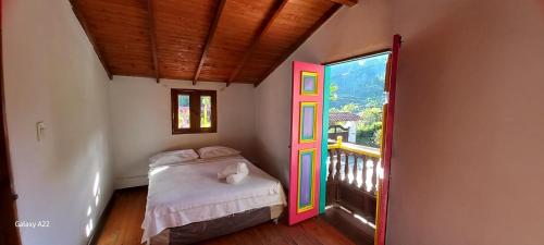 a bedroom with a bed with a colorful door at Finca y Chalet MA in Chiquinquirá