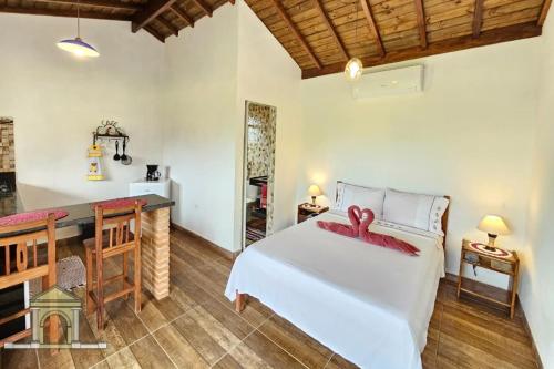 um quarto com uma cama com uma toalha vermelha em Chalés Vale dos Pássaros Refúgio nas montanhas em Paraty