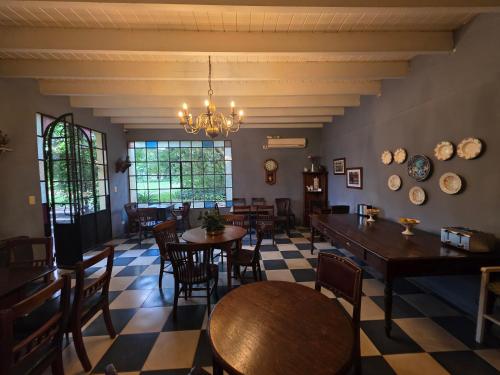 een eetkamer met tafels en stoelen en een kroonluchter bij Posada De La Plaza in San Antonio de Areco