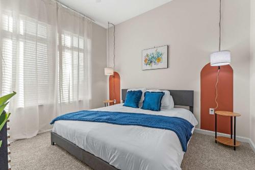 a bedroom with a large bed with blue pillows at Riviere 2BR Apartment Pet Friendly Oasis Sleeps 6 Close to Epic Universe Pool & Gym in Orlando