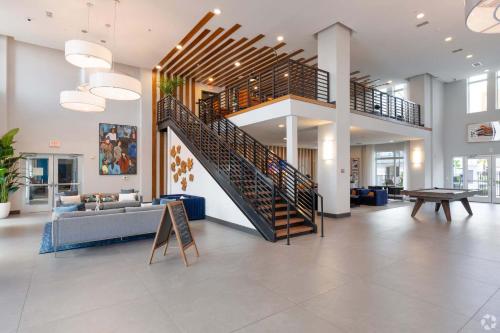 a living room with a staircase in a building at Riviere 2BR Apartment Pet Friendly Oasis Sleeps 6 Close to Epic Universe Pool & Gym in Orlando