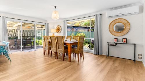 a dining room with a table and chairs at Evergreen Escape in Forster