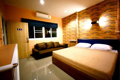 a bedroom with a bed and a couch at Urban Hostel Bangkok in Bangkok