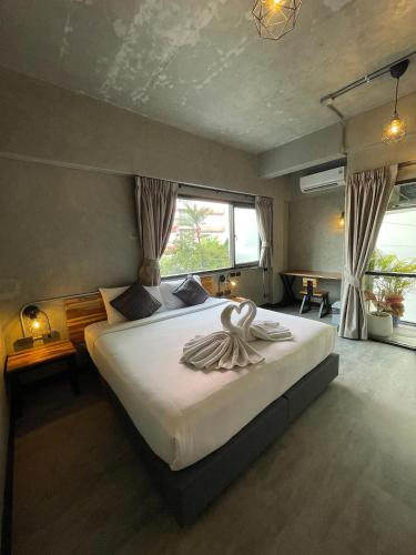 a bedroom with a large bed with white sheets at Mad Monkey Bangkok in Bangkok