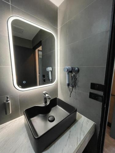 a bathroom with a black sink and a mirror at Mad Monkey Bangkok in Bangkok