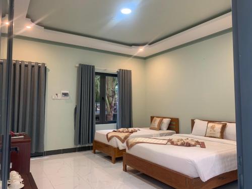 une chambre avec deux lits et une fenêtre dans l'établissement Salt & Wind Living - Phan Rang Beachfront, à Bắc Sớn