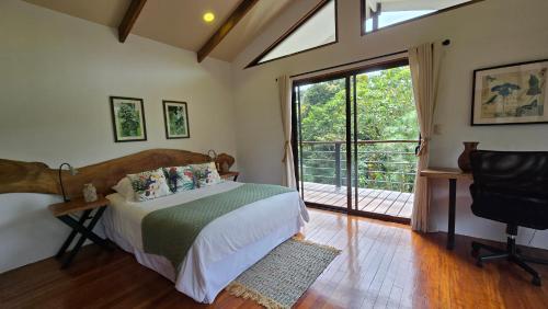 a bedroom with a bed and a sliding glass door at Monteverde Casa Mia, near main attractions and town! in Monteverde Costa Rica